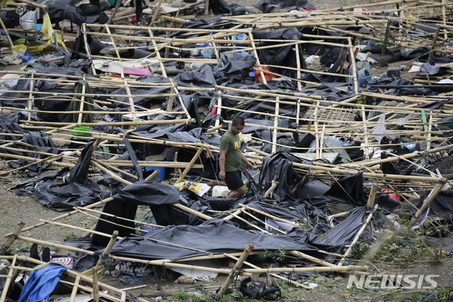 【투게가라오=AP/뉴시스】필리핀 카가얀주 투게가라오에서 16일 경찰 한 명이 슈퍼태풍 망쿳이 휩쓸고 지나가면서 완전히 파괴한 대피소 텐트들 사이를 지나가고 있다.2018.09.16 