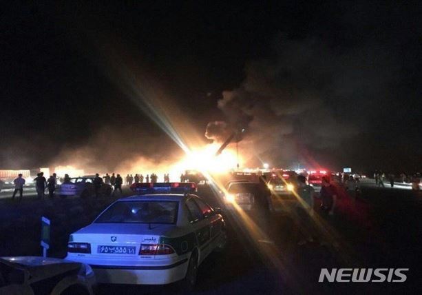 【서울=뉴시스】이란 중부에서 17일 밤 버스가 유조 트럭과 충돌한 후 전복되면서 화재가 발생해 최소 21명이 사망하고 20명이 부상하는 사고가 발생했다. 충돌 후 넘어진 버스가 불타고 있다. <사진 출처 " 이란 타스님 통신> 2018.9.18