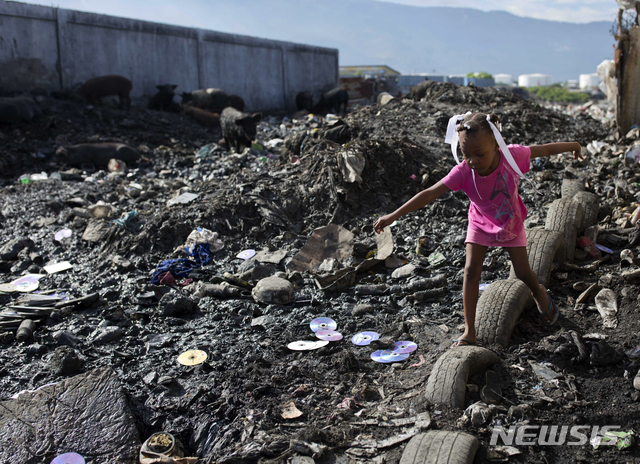 【 포르토프랭스( 아이티)= AP/뉴시스】 유엔이 발표한 다방면 빈곤지수의 빈곤국가이며 흔히 세계 최빈국으로 손꼽히는 아이티의 수도 포르토 프랭스에서 한 어린이가 지난 해 11월 쓰레기장에서 놀고 있다.  