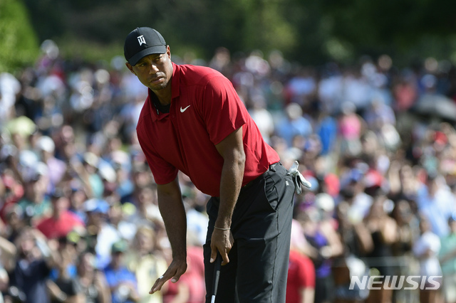 Tiger Woods motions for his putt for birdie to slow down as it passes the ninth hole during the final round of the Tour Championship golf tournament Sunday, Sept. 23, 2018, in Atlanta. (AP Photo/John Amis)