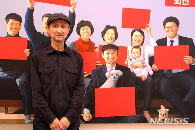 【서울=뉴시스】이종구 화백이 문구없는 붉은 피켓을 들고 있는 자신과 가족 그림을 그린 작품앞에서 포즈를 취했다.