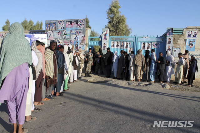 【카불=AP/뉴시스】아프가니스탄 남부 헬만드 주에서 20일 8년 만에 실시한 하원선거 투표에 참여하려는 유권자들이 삼엄한 경계가 펼쳐진 투표소 앞에 길게 늘어서서 차례를 기다리고 있다. 2018.10.21