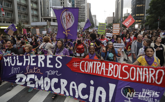 【상파울루(브라질)=AP/뉴시스】 21일(현지시간) 브라질 상파울루에서 열린 극우 사회자유당(PSL)의 자이르 보우소나루 후보 반대 집회에서 여성 유권자들이 "여자들은 민주주의를 위해 싸운다. 보우소나루에 반대한다"는 플래카드를 들고 행진 중이다. 2018.10.22.