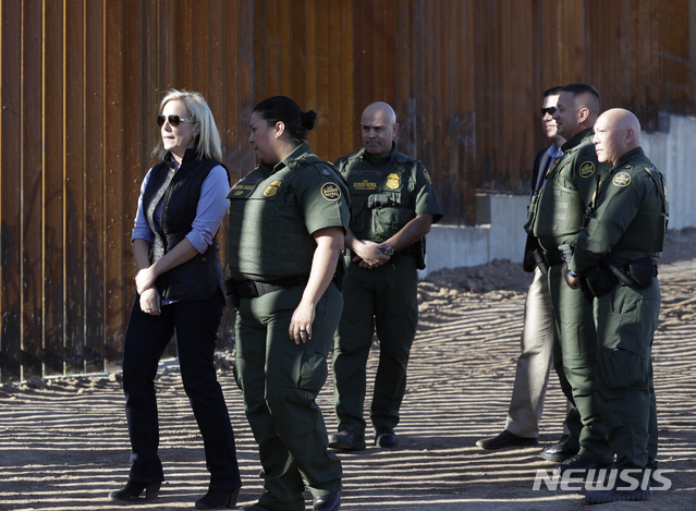 U.S. Department of Homeland Security Secretary Kirstjen Nielsen, left, walks with Border Patrol agents near a newly-fortified border wall structure Friday, Oct. 26, 2018, in Calexico, Calif. (AP Photo/Gregory Bull)