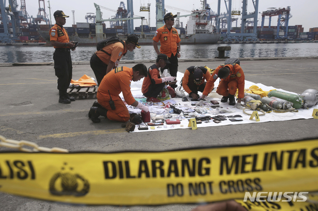 【자카르타=AP/뉴시스】인도네시아 구호요원들이 30일 자카르타 항구에서 라이온에어 여객기 추락 희생자들의 소지품으로 보이는 물건들을 조사하고 있다. 2018.10.30 