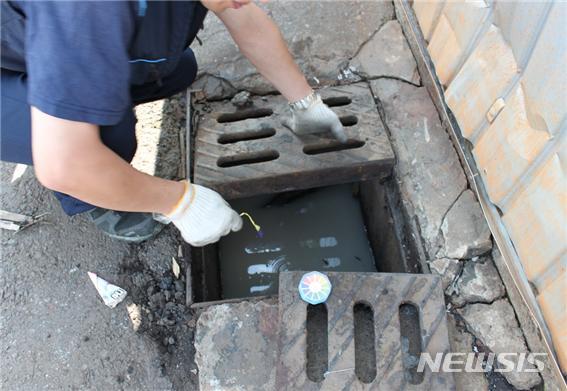 [대구=뉴시스] 무단 배출한 강알칼리 폐수를 단속반이 우수로 맨홀에서 확인하고 있다. 뉴시스DB