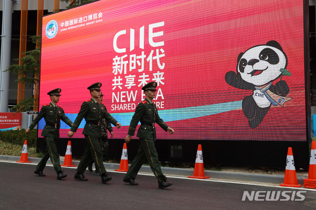 【상하이=AP/뉴시스】 적어도 수십 명의 젊은 노동운동가들이 중국에서 사라졌다고 뉴욕타임스가 11일 (현지시간) 보도했다. 사진은 지난 4일 상하이에서 개최된 세계무역 엑스포 행사광고판을 지나고 있는 공안들. 2018.11.12.