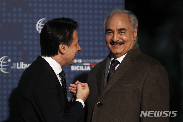 13일 이탈리아 팔레르모 정상회의에 참석한 리비아 동쪽 정부의 세력자 히프터 장군(오른쪽)이 콩테 총리와 악수하고 있다  AP