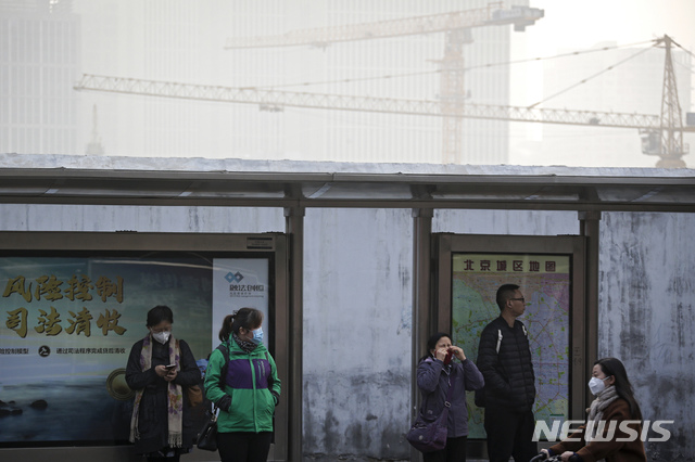 【베이징=AP/뉴시스】중국 베이징시에 13일 오전 8시 대기오염 황색(3급) 경보가 발령됐다. 이날 베이징 도심 한 정류소에서 마스크를 착용한 시민들이 버스를 기다리고 있다. 2018.11.13 