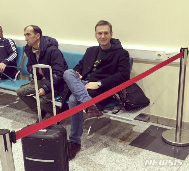 【모스크바=AP/뉴시스】러시아의 야당 지도자 알렉세이 나발니가 13일 모스크바 외곽의 도모데도보 국제공항에 붉은 리본으로 격리된 채 앉아 있다. 프랑스에 있는 유럽인권재판소(ECHR) 증언을 위해 출국하려던 나발니는 이날 공항에서 출국이 가로막혔다. 그는 러시아가 자신에 대해 출국 금지 조치를 내렸다고 블로그를 통해 밝혔다. 2018.11.13