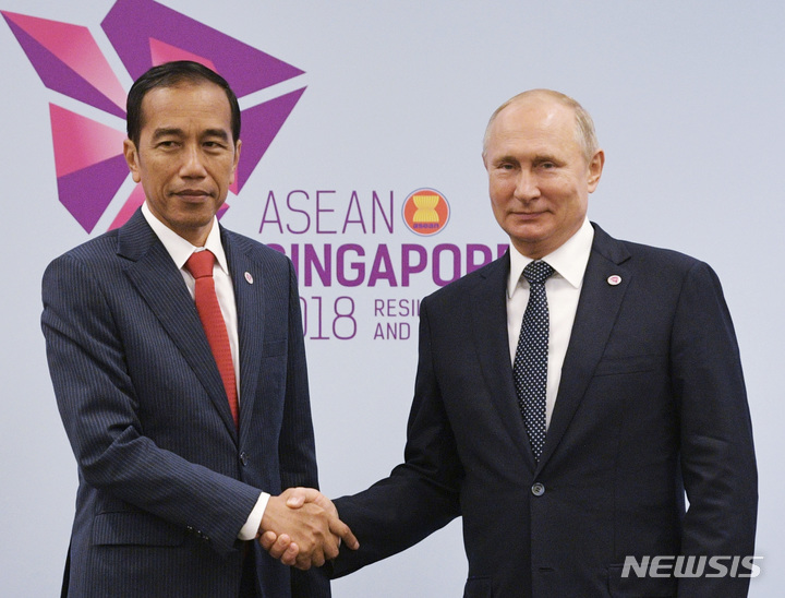 [싱가포르=AP/뉴시스]조코 위도도 인도네시아 대통령(왼쪽)이 지난 2018년11월14일 싱가포르에서 열린 아세안(ASEAN·동남아시아국가연합) 정상회의에 앞서 블라디미르 푸틴 러시아 대통령과 악수하고 있다. 2022.06.21.