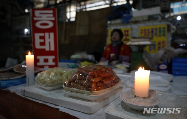 【서울=뉴시스】김선웅 기자 = 노량진 구(舊) 수산시장에 대한 단전·단수 조치가 지속되고 수협이 최대한 빠른 시일 내 구시장 철거 절차를 진행하겠다고 밝힌 21일 서울 동작구 구 노량진 수산시장에서 한 상인이 촛불을 켜고 영업을 하고 있다. 2018.11.21.  mangusta@newsis.com