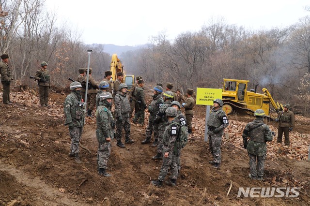 【서울=뉴시스】 국방부는 22일 남북군사당국이 '판문점선언 이행을 위한 군사분야 합의서'(9.19.)에 따라 공동유해발굴의 원활한 추진을 위해 강원도 철원 ‘화살머리고지’ 일대에서 남북 도로개설을 추진하고 있는 가운데, 도로연결 작업에 참여한 남북인원들이 MDL인근에서 상호 조우하는 모습의 사진을 공개했다. 2018.11.22. (사진=국방부 제공) photo@newsis.com