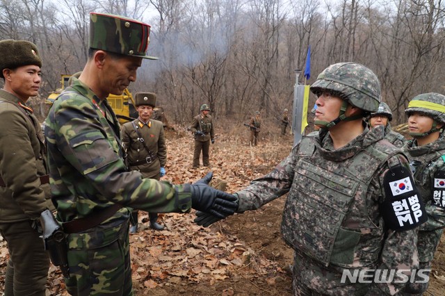 【서울=뉴시스】 국방부는 22일 남북군사당국이 '판문점선언 이행을 위한 군사분야 합의서'(9.19.)에 따라 공동유해발굴의 원활한 추진을 위해 강원도 철원 ‘화살머리고지’ 일대에서 남북 도로개설을 추진하고 있는 가운데, 도로연결 작업에 참여한 남북인원들이 MDL인근에서 상호 조우하는 모습의 사진을 공개했다. 2018.11.22. (사진=국방부 제공)  photo@newsis.com