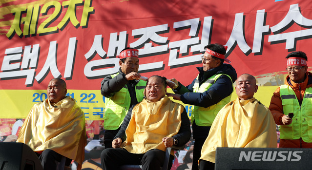 【서울=뉴시스】홍효식 기자 = 지난달 22일 오후 서울 여의도 국회 앞에서 열린 불법 카풀 앱 근절 제2차 택시 생존권 사수 결의대회에서 참가자들이 삭발식을 하고 있다. 2018.11.22. yesphoto@newsis.com