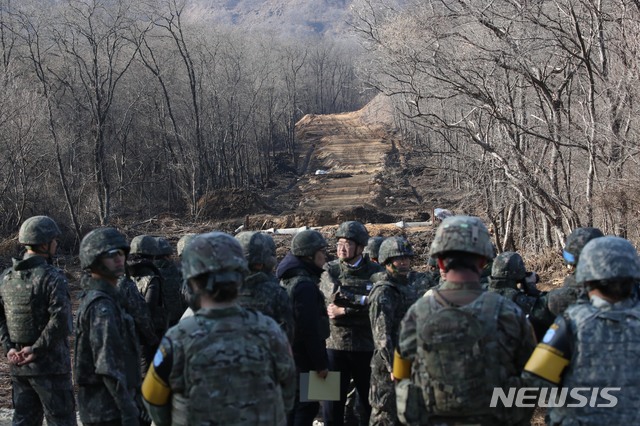 【철원=뉴시스】사진공동취재단 = 22일 오후 6ㆍ25 전쟁 당시 최대 격전지였던 강원도 철원 화살머리고지에서 남북이 비무장지대(DMZ) 안에서 아직까지 수습하지 못한 6ㆍ25 전쟁 전사자 유해를 공동으로 발굴하는 사업을 위한 남북공동 도로개설 작업 가운데 우리측 지역의 도로공사 현장을 국방부가 공개 했다.  남측 취재단이 군사분계선(MDL 사진속 건너편은 북한 지역이다) 바로 앞에서 취재하고 있다. 남북은 지난 9월19일 체결한 군사합의서에서 원활하게 유해를 발굴하기 위해 12ｍ 폭의 도로를 개설하고 군사분계선에서 연결한다고 합의 했다. 2018.11.22. photo@newsis.com