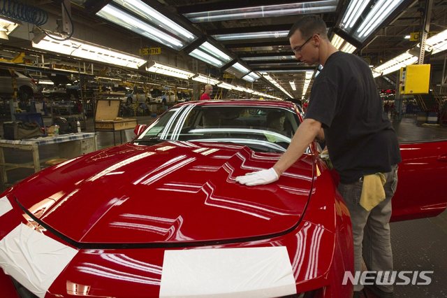 FILE - In this June 10, 2011, file photo, a worker checks the paint on a Camaro at the GM factory in Oshawa, Ontario. General Motors is closing a Canadian plant at the cost of about 2,500 jobs, but that is apparently just a piece of a much broader, company-wide restructuring that will be announced as early as Monday, Nov. 26, 2018. (Frank Gunn/The Canadian Press via AP, File)