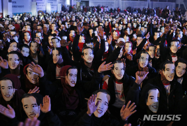 【보고르=AP/뉴시스】 인도네시아 자바의 서부 도시 보고르에서 조코 위도도 인도네시아 대통령의 가면을 쓴 지지자들이 손을 흔들고 있다. 2019.03.19.