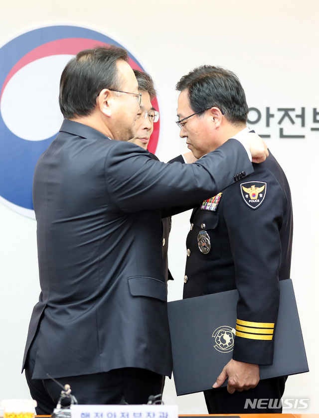 【서울=뉴시스】전진환 기자 = 신임 경찰지휘부 임명장 수여식이 열린 3일 오후 서울 종로구 행정안전부에서 김부겸 행안부 장관이 치정감으로 승진한 이용표 신임 부산경찰청장에게 계급장을 달아주고 있다. 2018.12.03.  amin2@newsis.com