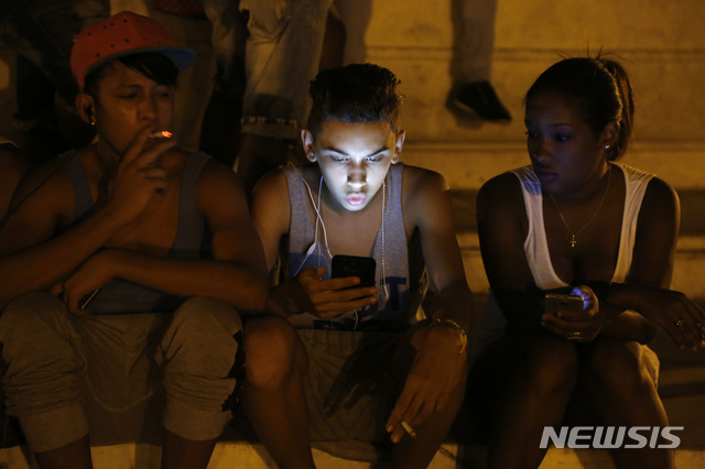 【아바나(쿠바)= AP/뉴시스】차미례 기자 = 2015 년 7월 쿠바 아바나시내의 5성급 대형관광호텔 앞에서 스마트폰으로 인터넷 접속을 시도하고 있는 청소년들. 쿠바 정부는 12월 4일 일반국민에게도 휴대전화 인터넷 접속을 허용한다고발표했고, 6일 국영전화회사는 문자로서비스가 시작되었다고 공지했다.  