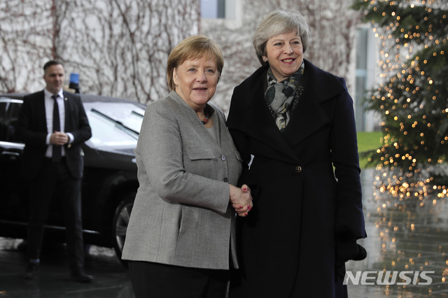 British Prime Minister Theresa May, right, is greeted by German Chancellor Angela Merkel upon her arrival at the chancellery in Berlin, Tuesday, Dec. 11, 2018. (AP Photo/Markus Schreiber)