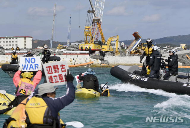 【헤노코(오키나와)=AP/뉴시스】일본 정부가 14일 일본 오키나와(沖繩)현 나고(名護)시 헤노코(邊野古) 해안에서 미군기지 이전을 위한 매립 공사를 강행하자, 현민들이 매립 예정지인 바다로 나와 '전쟁 반대' '매립중단' 이라고 적힌 팻말을 들고 시위를 벌이고 있다. 2018.12.14.