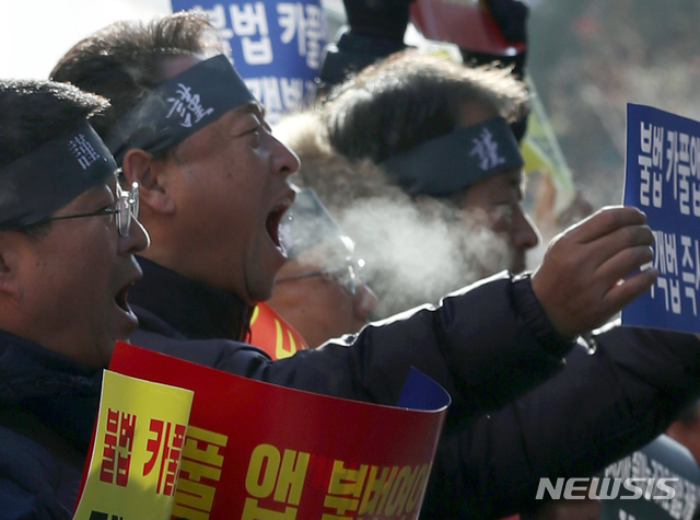 【서울=뉴시스】고승민 기자 = 중부와 경북 내륙에 한파 특보가 내려진 가운데 서울 개인택시운송사업조합 소속 택시기사들이 14일 오전 서울 여의도 더불어민주당사 앞에서 카풀 규탄 및 생존권 사수 결의대회를 하며 입김을 내 뿜고 있다. 2018.12.14.  kkssmm99@newsis.com 