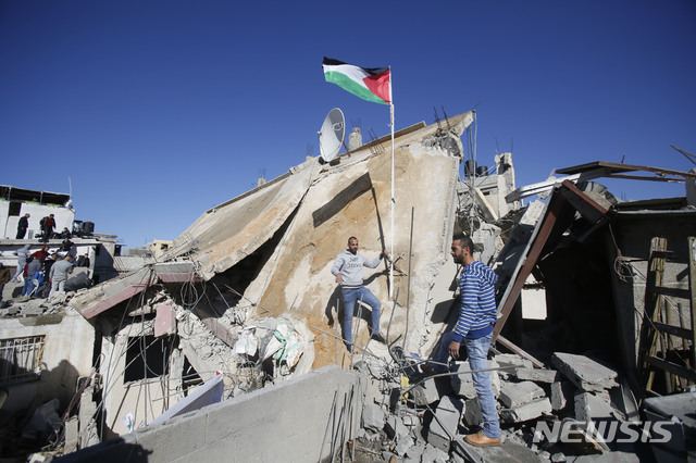 【라말라( 서안지구) = AP/뉴시스】 12월 15일(현지시간)  서안지구의 팔레스타인 주민들이 몇 달 전 반이스라엘 시위에 가담했던 아부 흐마이드 일가의 주택이 이스라엘군 포격으로 폐허가 된 것을 살펴보고 있다.   