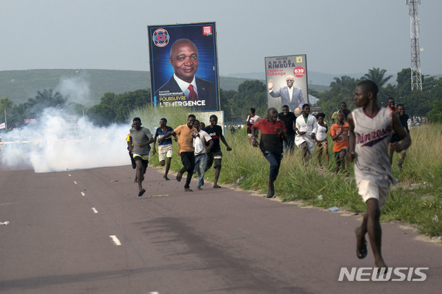 대선을 앞둔 콩고민주공화국에서 지난 19일 야당 후보 파율루 지지자들이 경찰의 최루탄에 도망가고 있다    AP  