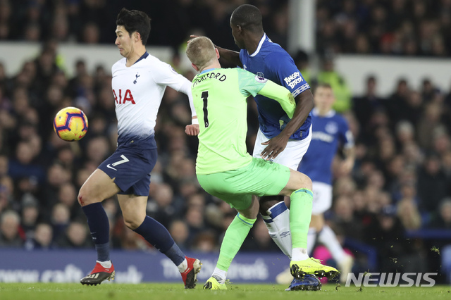 Everton goalie Jordan Pickford, center, collides with teammate Kurt Zouma, right, as Tottenham&#039;s Son Heung-min, left, scores during the English Premier League soccer match between Everton and Tottenham at Goodison Park Stadium, in Liverpool, England, Sunday, Dec. 23, 2018. (AP Photo/Jon Super)