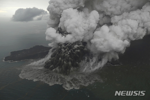 【AP/뉴시스】 인도네시아 순다 해협에 위치한 아낙 크라카타우 화산에서 23일 검은 연기와 화산재가 뿜어져 나오고 있다. 이 화산은 전날 폭발하면서 거대한 쓰나미를 일으켜 막대한 인명피해를 초래했다. 2018.12.25 