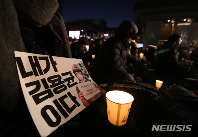 【서울=뉴시스】이윤청 수습기자 = 지난달 29일 오후 서울 종로구 광화문광장에서 열린 고 김용균 2차 범국민 추모제에서 참석자들이 촛불과 피켓을 들고 있다. 2018.12.29. radiohead@newsis.com