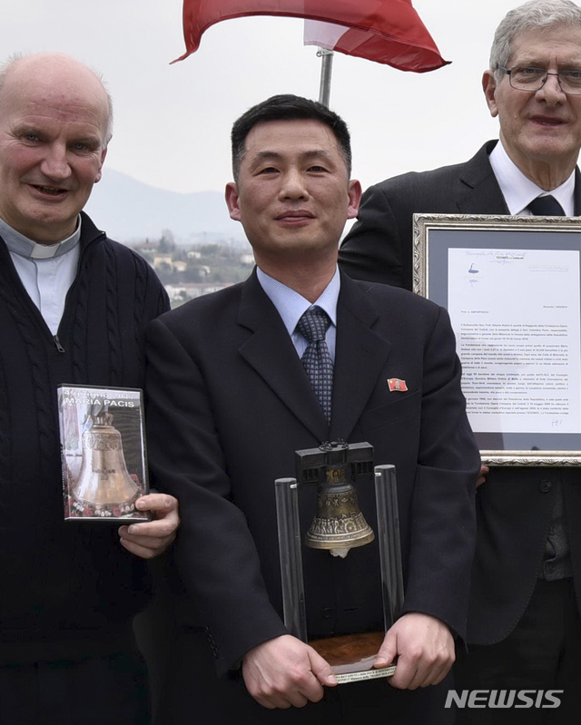  【서울=AP/뉴시스】국가정보원은 3일 조성길 이탈리아주재 북한 대사대리의 망명설과 관련해 "지난해 11월 초 공관을 이탈해 부부가 함께 잠적했다"고 밝혔다. 사진은 지난해 3월20일 조성길(가운데) 이탈리아주재 북한 대사대리가 이탈리아 산피에트로디펠레토에서 열린 문화 행사에서 '로베레토 자유의 종'을 들고 있는 모습. 2019.01.03. 