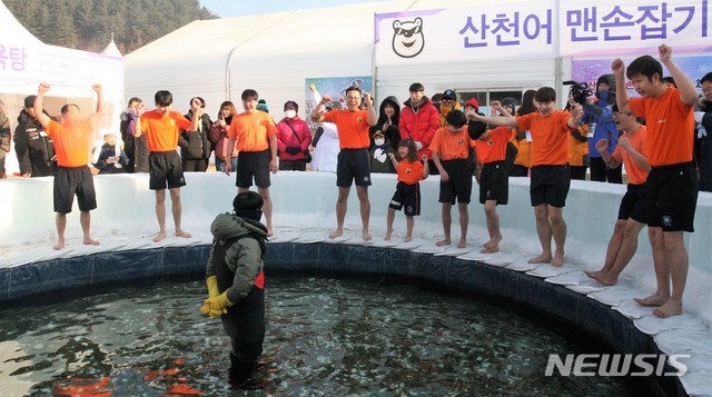 【화천=뉴시스】박종우 기자 = 2019 화천 산천어축제장 개막일인 5일 강원 화천군 화천읍 화천천 축제장에 마련된 체험장에서 방문객들이 산천어 맨손잡기에 나섰다. 2019.01.05  jongwoo425@newsis.com