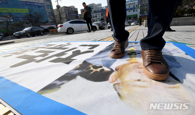 【광주=뉴시스】신대희 기자 = 사자명예훼손 혐의를 받고 있는 전두환씨의 형사재판이 열리는 7일 오후 광주지법 입구쪽에서 한 시민이 전씨 현수막을 밟고 지나가고 있다. 2019.01.07. sdhdream@newsis.com