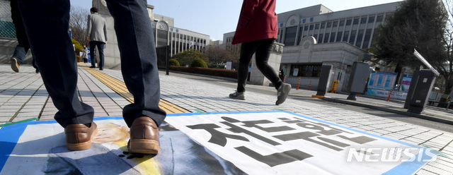 【광주=뉴시스】신대희 기자 = 사자명예훼손 혐의를 받고 있는 전두환씨의 형사재판이 열리는 7일 오후 광주지법 입구쪽에서 한 시민이 전씨 현수막을 밟고 지나가고 있다. 2019.01.07. sdhdream@newsis.com