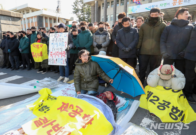 【제주=뉴시스】우장호 기자 = 7일 오후 제주도청 앞 현관과 인도에서 제2공항 반대 천막 행정대집행이 진행된 가운데 천막을 빼앗긴 성산읍 주민 김경배씨가 도로 위에 누워 있다. 2019.01.07.  woo1223@newsis.com