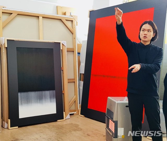 【서울=뉴시스】 박현주 미술전문기자 = 김수수 작가가 용광로의 불의 이미지를 색면추상화로 작업한 그림에 대해 설명하고 있다.