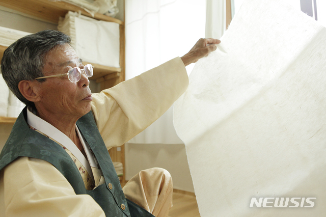  【문경=뉴시스】김진호 기자 = 경북도 무형문화재인 김삼식 한지장이 문경전통한지를 살펴보고 있다. 2019.01.24 (사진=문경시 제공) photo@newsis.com 