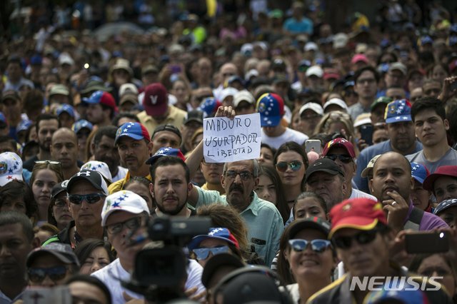 【카라카스(베네수엘라)=AP/뉴시스】베네수엘라 수도 카라카스에서 26일 니콜라스 마두로 대통령에 반대하는 시위가 열린 가운데 한 남성이 "마두로는 권력 찬탈범. 자유를 돌려달라"고 스페인어로 쓰인표지를 들고 있다. 베네수엘라는 이날 당초 72시간이던 미 외교관들의 출국 시한을 늦추었다. 베네수엘라 외교부는 성명에서 미국의 이익을 대변할 대표부 설치 문제를 논의 중이며 논의가 계속되는 동안 미 외교관들은 베네수엘라에 머물 수 있다고 밝혔다. 논의는 30일의 기간 중 이뤄질 예정이다. 2019.1.27