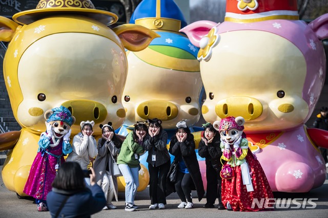 【서울=뉴시스】에버랜드 체험존 '찍으면 돼지'의 '황금돼지 3형제'을 배경으로 사진 찍는 관람객들.