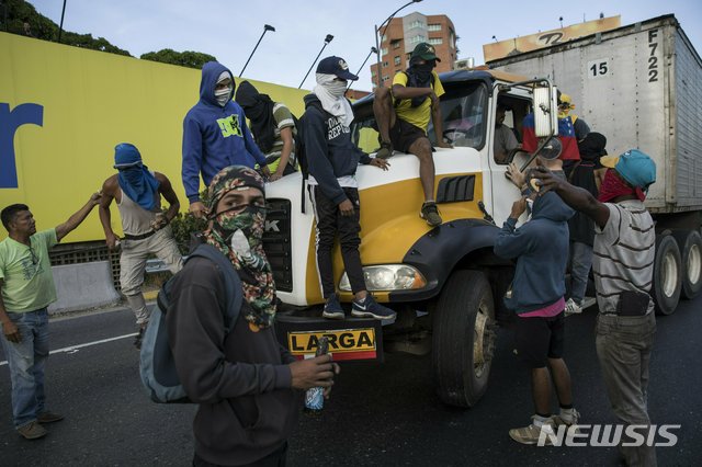 【카라카스=AP/뉴시스】지난 2일(현지시간) 베네수엘라 수도 카라카스에서 대규모 반정부집회가 열려 고속도로가 봉쇄된 가운데 시위대가 트럭을 정지시키고 있다.2019.02.03.