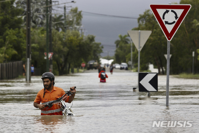 【타운즈빌=AP/뉴시스】호주 북동부 지역에 기록적 폭우가 내리면서 홍수 피해가 발생했다. 3일(현지시간) 타운즈빌 한 공원에서 허리까지 찬 물을 헤치고 시민들이 걸어가고 있다. 