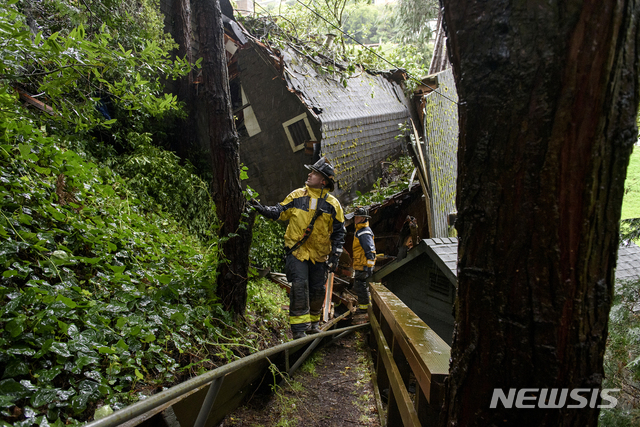 【AP/뉴시스】 폭우와 진흙 산사태로 지반이 무너져 옆으로 쓰러진 캘리포니아 산불지역의 한 주택.  