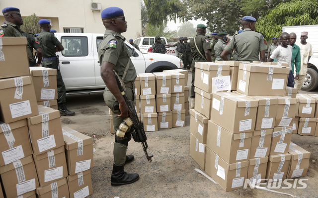 【욜라(나이지리아)=AP/뉴시스】나이지리아 대선을 하루 앞둔 15일(현지시간) 욜라의 나이지리아 선거관리위원회에서 관계자들이 각 투표소로 보내는 투표용지를 트럭에 싣는 동안 무장 경찰이 삼엄하게 주변을 경계하고 있다. 2019.02.15.