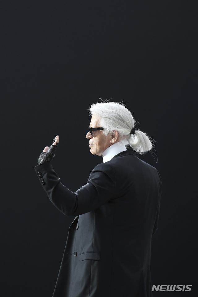 【파리=AP/뉴시스】지난 50년간 디자인뿐 아니라 자신의 트레이드마크인 흰색 말총머리, 풀 먹인 빳빳한 옷깃, 수수께끼의 짙은 안경으로 하이패션 업계를 주름잡았던 샤넬의 상징적인 패션 디자이너 카를 라거펠트가 85세의 나이로 별세했다. 사진은 라거펠트가 2013년 3월5일 파리에서 열린 2013-14 샤넬 추동 기성복 패션쇼를 마치고 인사하는 모습. 2019.02.19.
