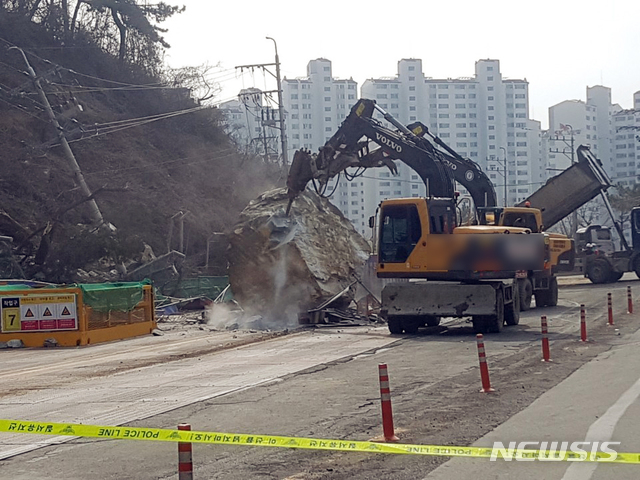 【부산=뉴시스】 하경민 기자 = 22일 부산 사상구 엄궁동과 사하구 하단동 사이 지하철 공사구간 옆 산비탈 절개지에서 붕괴 우려가 나타나 주변 도로를 경찰이 통제 중인 가운데 산 위에서 큰 바위가 도로로 굴러 떨어졌다. 2019.02.22. (사진=부산경찰청 제공)yulnetphoto@newsis.com