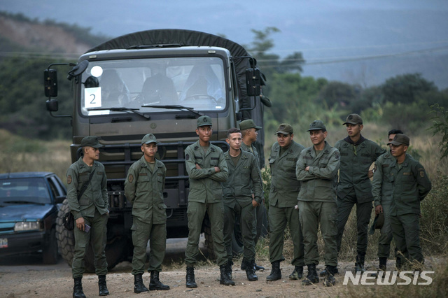 【우레나(베네수엘라)=AP/뉴시스】베네수엘라 군인들이 21일 베네수엘라와 콜롬비아를 잇는 우레나의 티엔디타스 교량 입구를 지키고 서 있다. 미국이 지원한 구호품 반입을 둘러싸고 대립이 계속되는 가운데 브라질과의 국경지대에서 22일 구호품을 받으려는 원주민들과 이를 막으려는 군 사이에 충돌이 발생해 여성 1명이 사망하고 12명이 부상했다. 2019.2.23