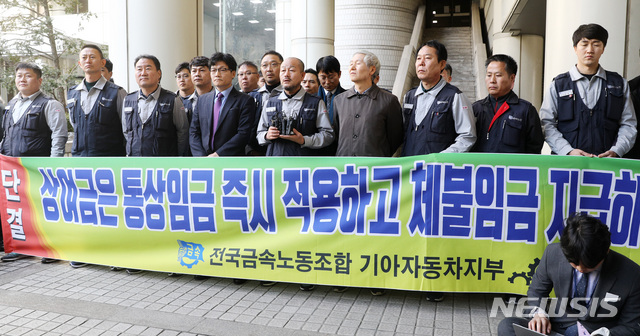 [서울=뉴시스]이영환 기자 = 지난해 2월22일 오후 서울 서초구 서울고등법원 앞에서 전국금속노동조합 기아자동차지부 강상호 지부장과 노조원들이 통상임금 소송 항소심 결과 관련 기자회견을 하고 있다. 2019.02.22. 20hwan@newsis.com