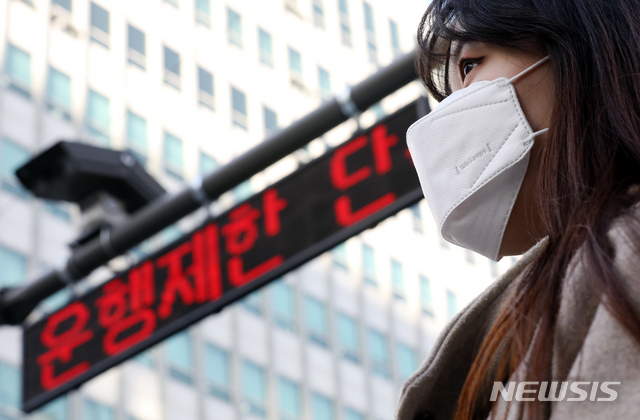 【서울=뉴시스】김병문 수습기자 = 서울 중구 서소문동 일대에서 마스크를 착용한 시민 뒤로 노후차량 운행 단속 CCTV가 보이고 있다. 2019.02.22. dadazon@newsis.com